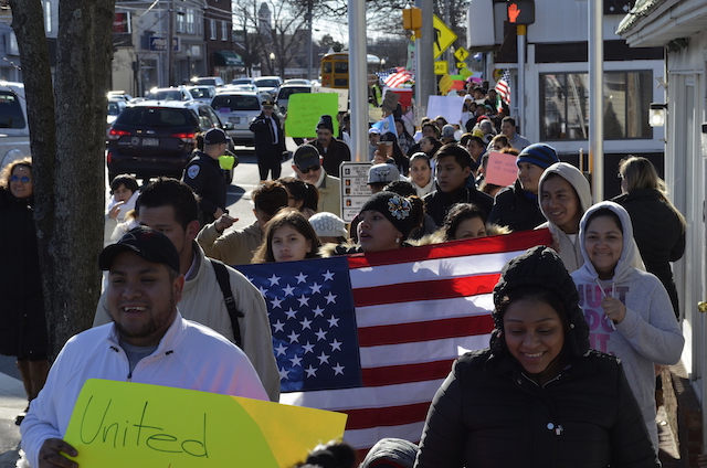 People filled the sidewalk, chanting and holding signs.