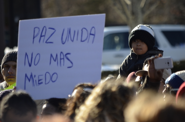 A young marcher by a sign that reads,