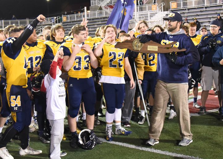 Coach Matt Millheiser holds the championship plaque. (Credit: Robert O'Rourk)