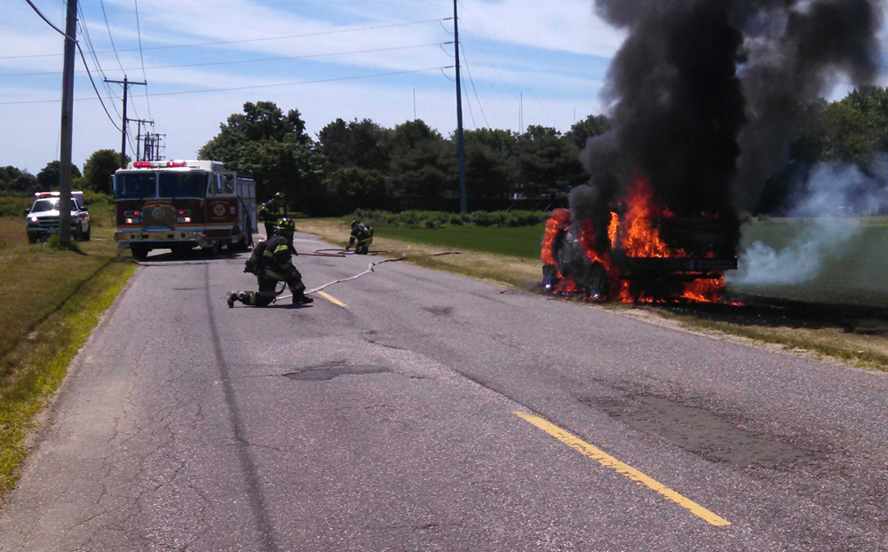 Jamesport Fire Department volunteers extinguish a vehicle fire on Tuthills Lane in jamesport Sunday. (Credit: Jamesport Fire Department)