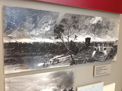 PAUL SQUIRE PHOTO | A reproduction of a painting of a forest fire in the Long Island Pine Barrens is featured in an exhibit detailing the history of the island's oldest forests. 