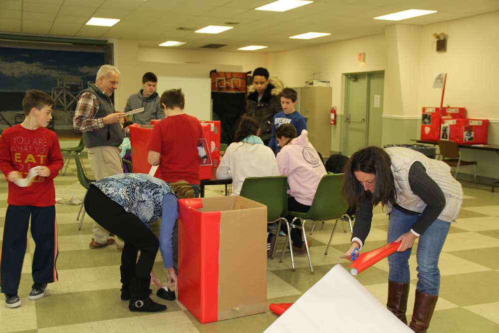 Special projects coordinator Phillip Beltz helps youth bureau members decorate donation boxes for the North Fork Animal Welfare League. 