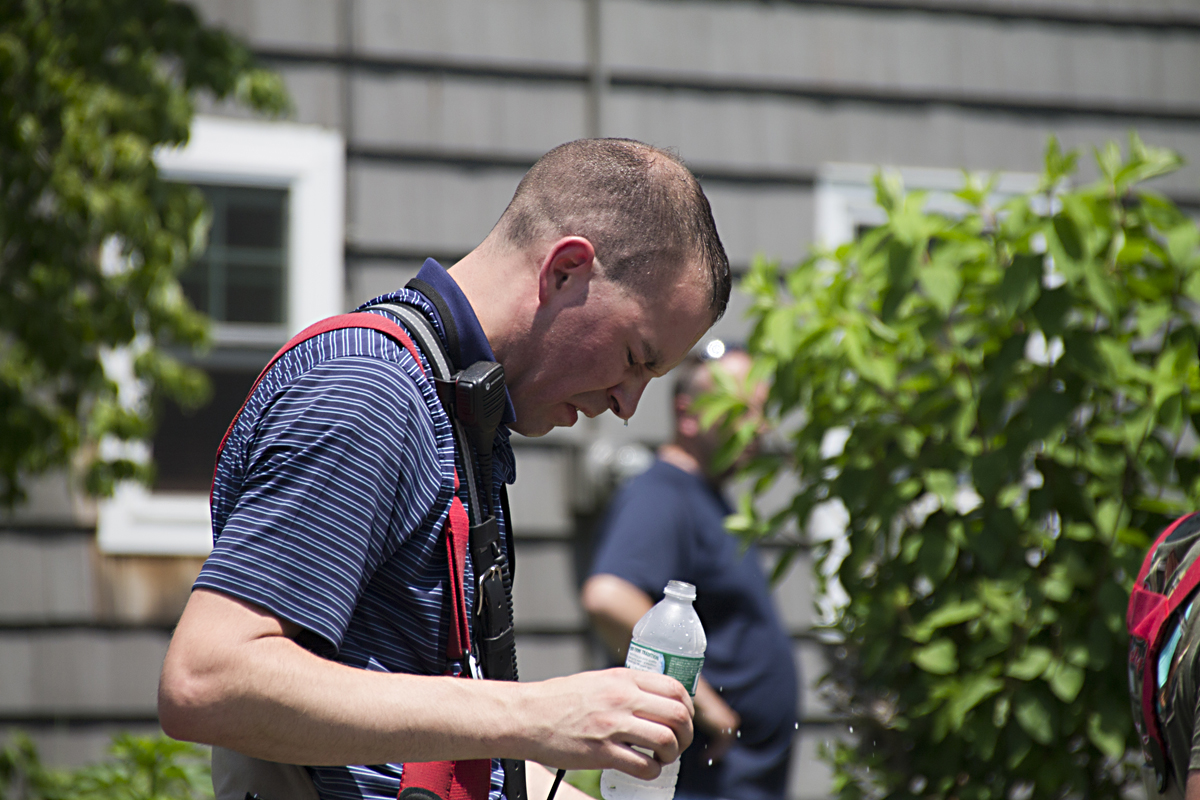 A firefighter tries to cool off. Temperatures around the house fire reached nearly 90 degrees. (Credit: Paul Squire)