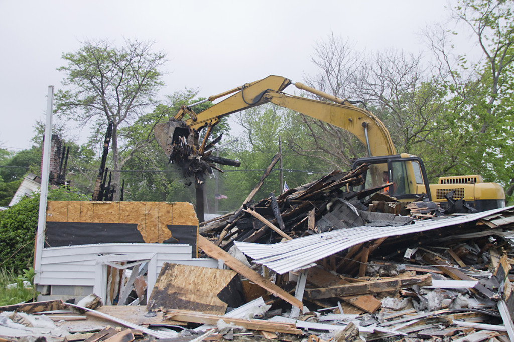 Construction crews load the remains of the First Universalist Church into dumpsters at the site Thursday morning.