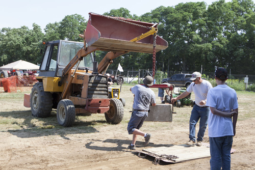 Drivers hauling cement blocks onto the pull platform.