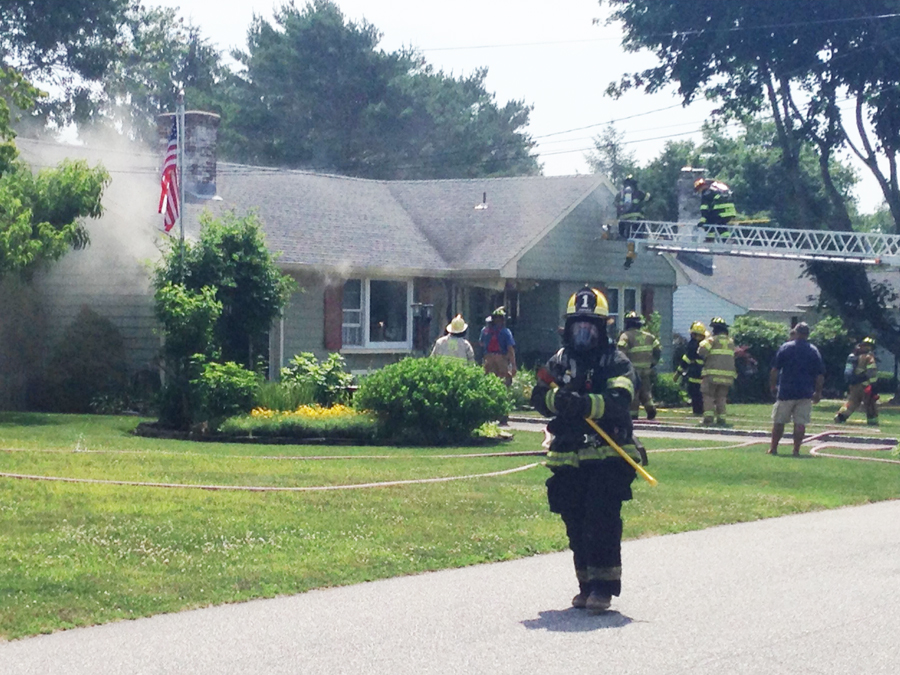 Firefighters knock down smoke at the Gillette Drive house in East Marion Thursday. (Credit: Paul Squire)