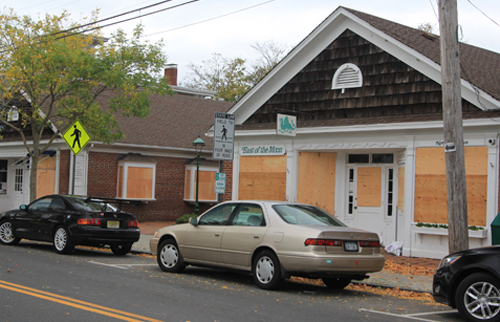 GReenport_storm JENNIFER GUSTAVSON PHOTO | Businesses on Front Street in Greenport Village protecting their glass storefronts with plywood Sunday afternoon.