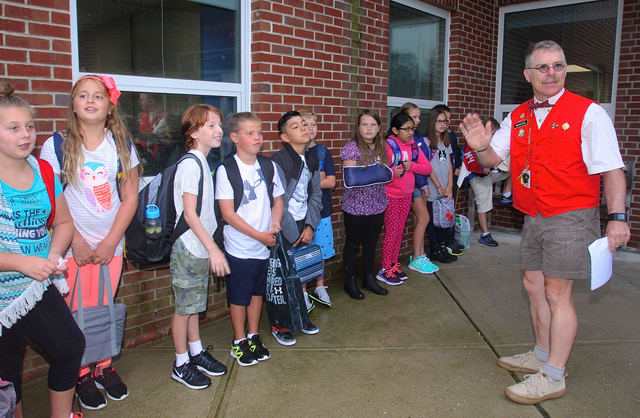Fourth grade teacher Skip Munisteri, now in his 22nd year, gathers his class outsise so they can all go in together. 