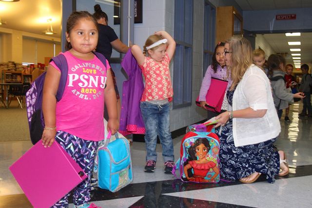 Kindergartner Maritza Fuentes-Olguin waits as her teacher Karen Krukowski talks with other students.