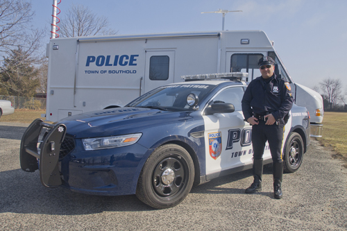 Highway patrol officer Peter Onufrak stands in front of the department's new Police Interceptor cruiser.
