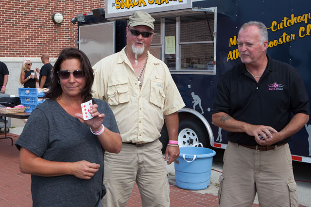 Lori Kazic, left, and Andrew Vogeney, center tied for second best poker hand, then drew a card to decide the winner. They both drew a 9.  Andrew ended up winning and donating his prize back to Kait's Angels. (Credit: Katharine Schroeder)
