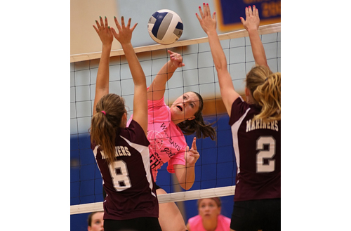 Emilie Reimer, who had 10 kills for Mattituck, found room to hit the ball between Southampton's Maddy Elliston (8) and Lexi Rusko. (Credit: Garret Meade)