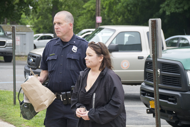 Nuria Russell is escorted into Southold Town Justice Court Tuesday. (Credit: Paul Squire)