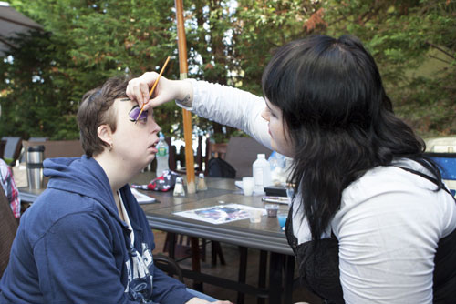 Katie Johnson applies face paint to Tara Yoos.