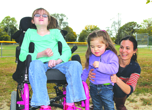 CARRIE MILLER PHOTO | Rachel Garms, 11, of Southold with Maren DeSantis, 2, and Maren's mother, Lena, of Mattituck at Tasker Park in Peconic last Saturday. The two girls met for the first time during October, Rett Syndrome Awareness Month.