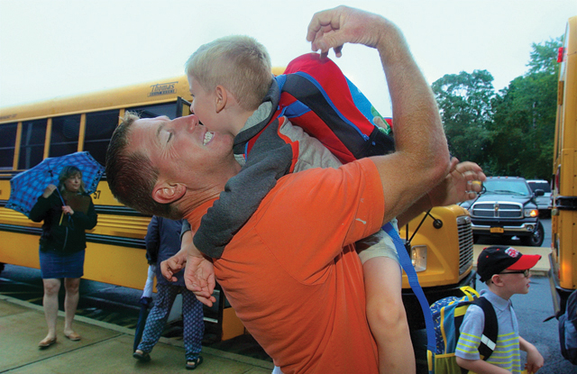 Robert Bohn raced to school to greet his son Hudson, 6, as he excited the bus. 