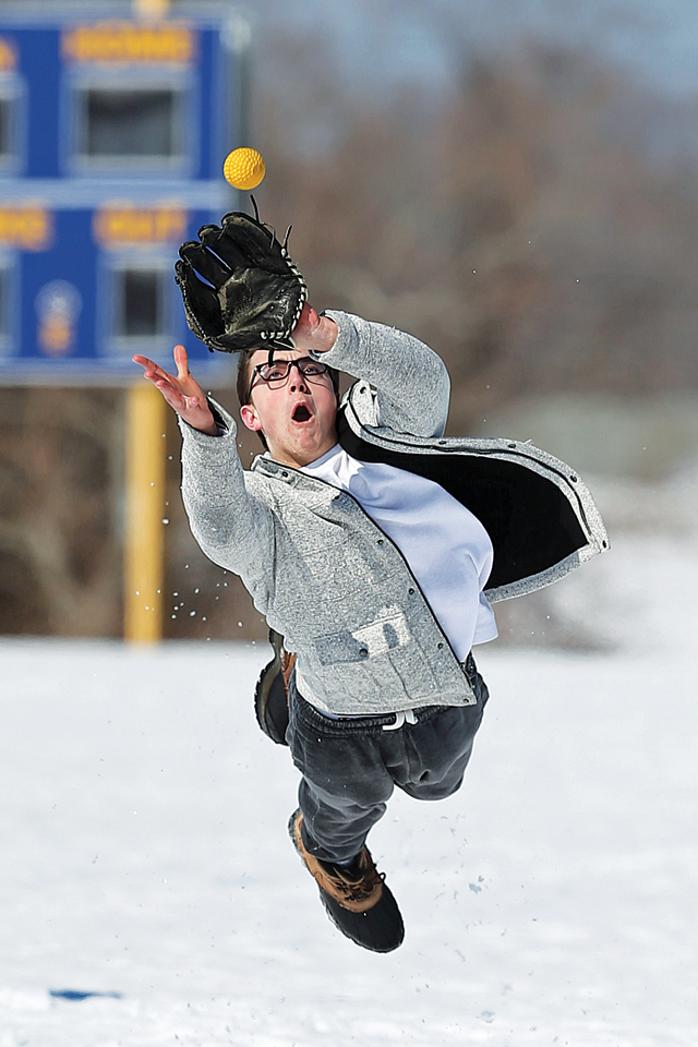 Jonathan Dwyer dives to catch the ball on a snowy field. Mattituck HS had its first outdoor practice of the season in the snow on March 9th 2015.Daniel De Mato
