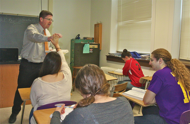 Greenport High School AP biology teacher Christopher Buckley gives student Sophia Albizures a high-five after she correctly answers a question about Mendelian genetics. (Credit: Barbaraellen Koch)