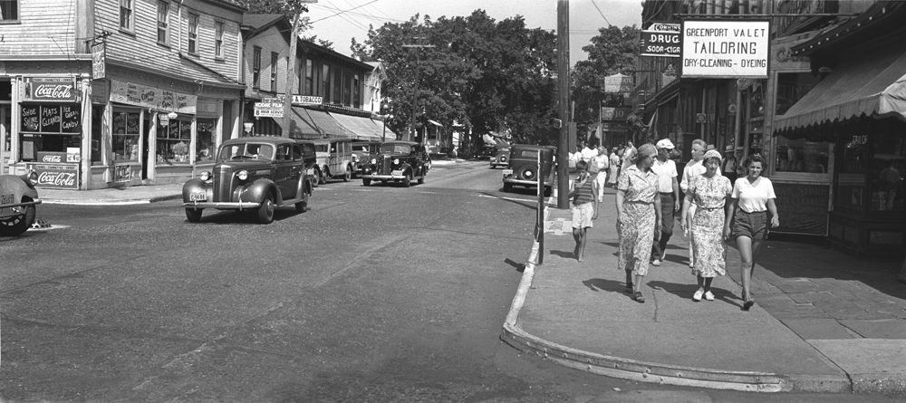 A 1950s photo of Greenport's Main Street. To the left of the photo in the street is a raised storm drain, originally installed to prevent injury to horses from stepping in the drains.