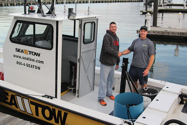 Patrick O’Halloran (left) and Garrett Moore met for the first time Tuesday evening in the Mitchell Park marina, hours after a joint effort to rescue six boaters and bring an out-of-control cigarette boat to a halt in the waters of Greenport Harbor. (Credit: Jen Nuzzo)