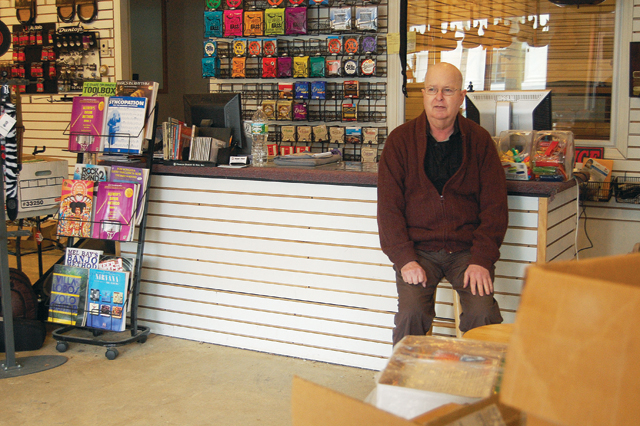 Ninow's owner Ralph Vail sits amongst boxed up music books in his Riverhead store in downtown Tuesday. (Credit: Cyndi Murray)