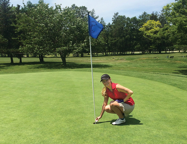 Catherine Brabazon of Greenport picks the ball out of the cup after acing her first hole-in-one on the third hole at Island's End Country Club in Greenport. (Credit: Jay Dempsey)