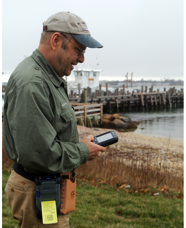 Photo: North Ferry General Manager Bridg Hunt demonstrating the new hand-held devices for ticketing. (Photo: Beverlea Walz)