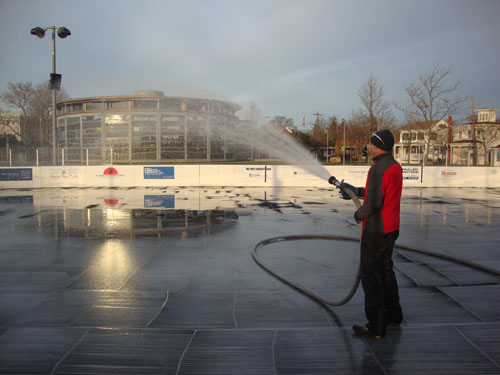 DAVID ABATELLI PHOTO | Michael Croteau, who coaches hockey on the rink on Sunday mornings, wets the Greenport Village ice rink to prep it for its opening.